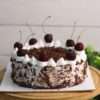 A rich chocolate cake known as 'Black Forest Cake,' featuring whipped cream and cherries, topped with chocolate shavings and whole cherries.