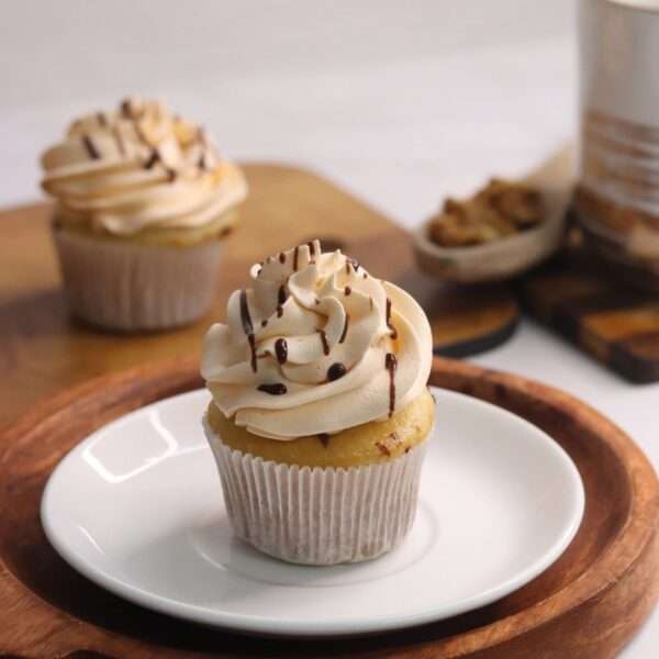 Sea salt caramel cupcake with whipped cream piping and caramel drizzle