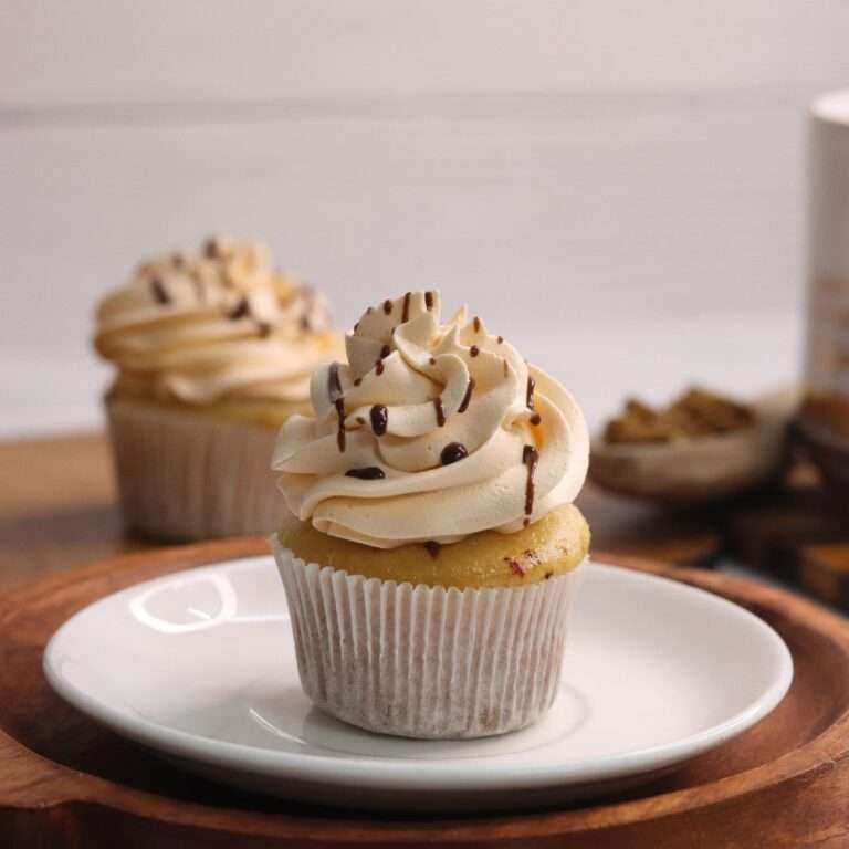 Sea salt caramel cupcake with whipped cream piping and caramel drizzle