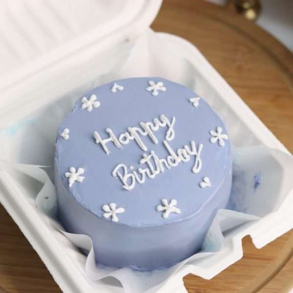A blue bento cake with white flower design