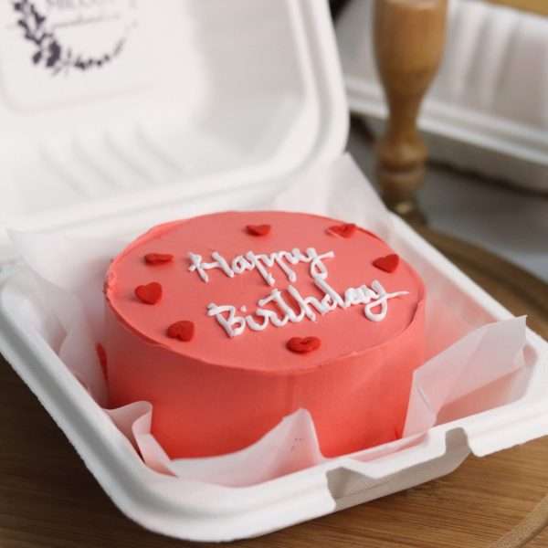 A red bento cake with heart sprinkles