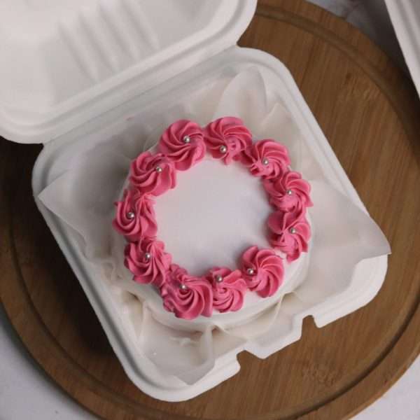 white bento cake with pink swirls on its side